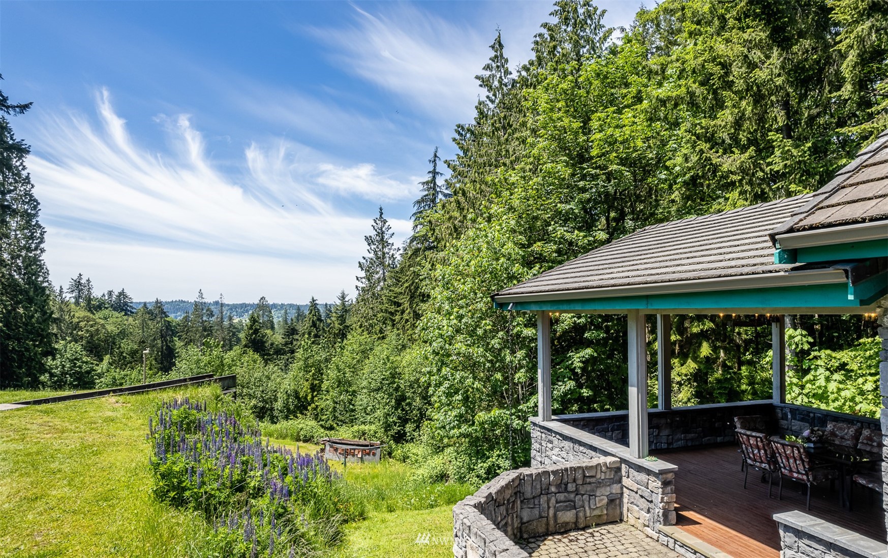 21632 High Rock Road Monroe, WA 98272 - Photo 30 of 40 a backyard of a house with lawn chairs plants and large tree