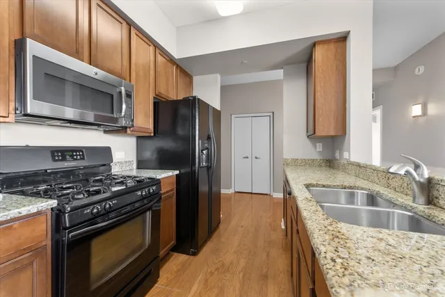 a kitchen with stainless steel appliances granite countertop a stove microwave sink and refrigerator
