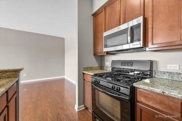 a kitchen with stainless steel appliances granite countertop a stove microwave and sink