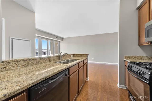 a kitchen with granite countertop a sink stove and cabinets
