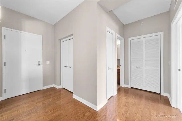a view of empty room with wooden floor