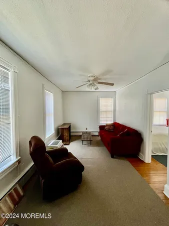 a living room with furniture a ceiling fan and a window