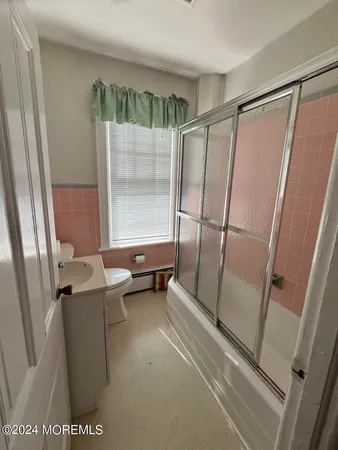 a bathroom with sink shower and toilet