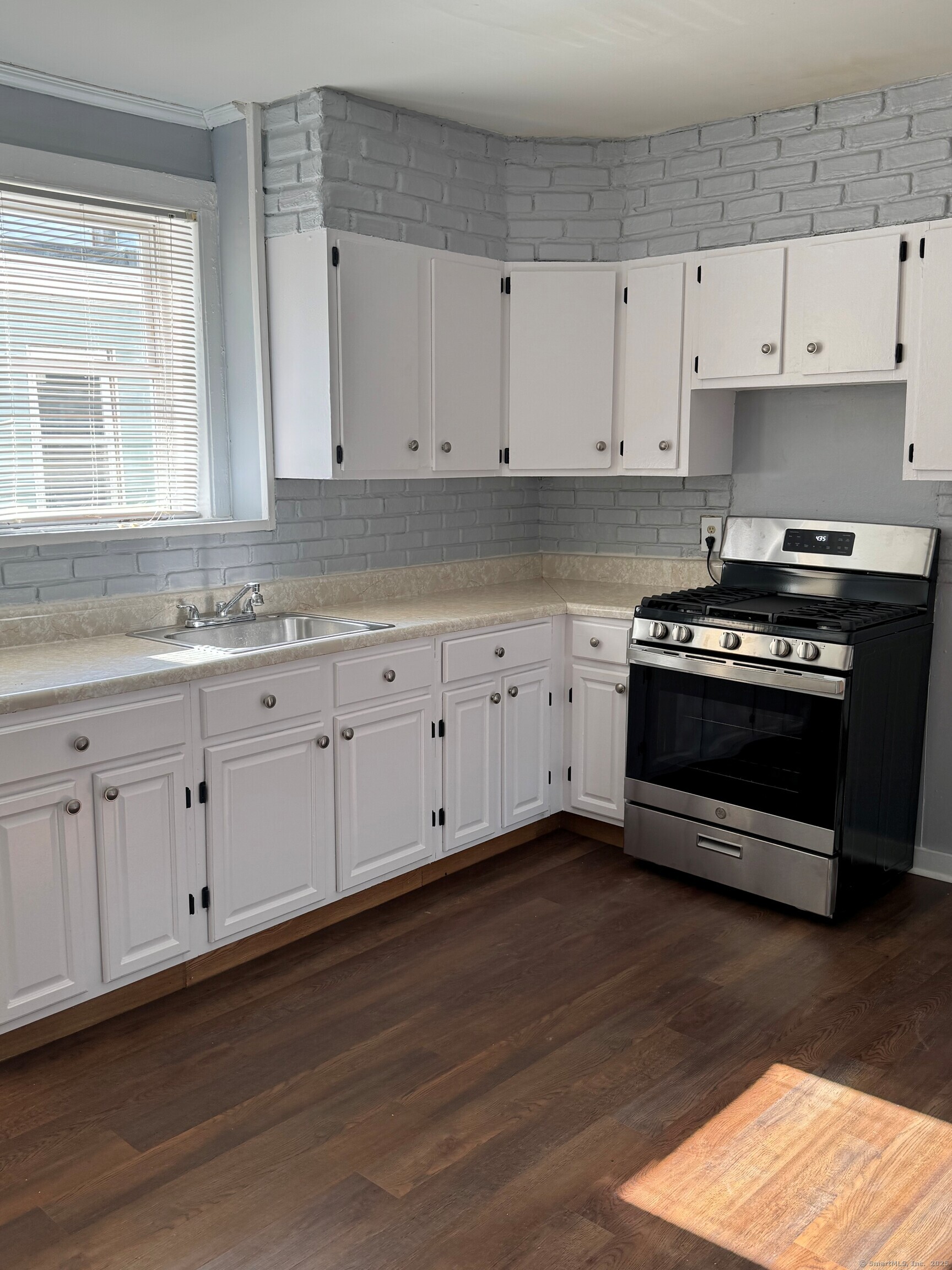 Undisclosed Address Bridgeport, CT 06605 - Photo 1 of 1 a kitchen with granite countertop a stove a sink and white cabinets