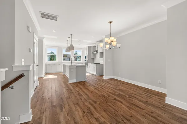 a view of kitchen with granite countertop cabinets a sink dishwasher and a stove with wooden floor
