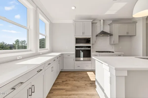 a open kitchen with a sink a refrigerator and wooden floor