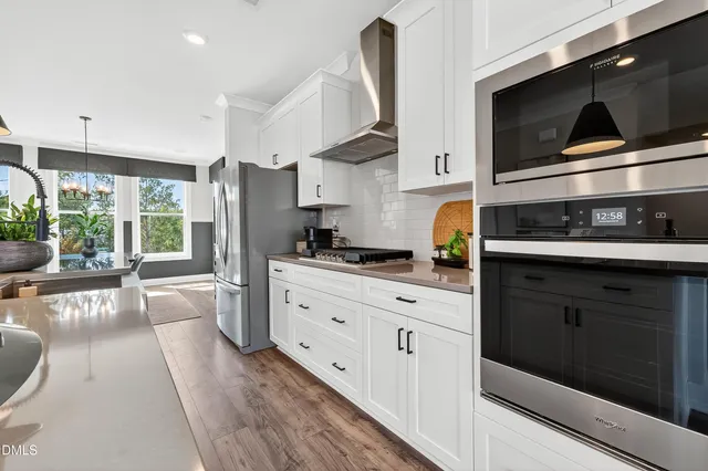 a kitchen with stainless steel appliances kitchen island granite countertop a stove a sink and a microwave