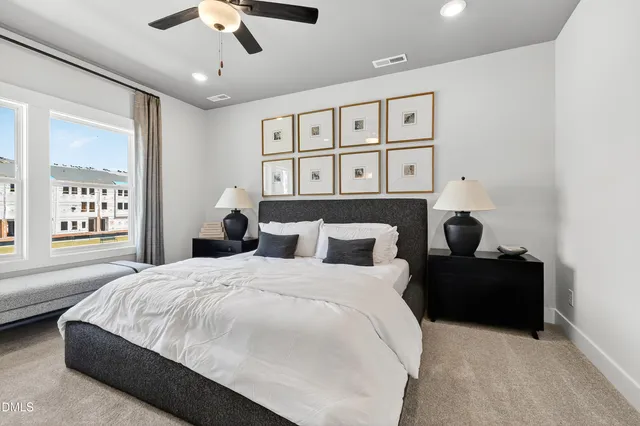 a bedroom with a bed painting on wall and a large window