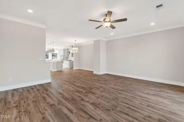 a view of a livingroom with a ceiling fan & wooden floor