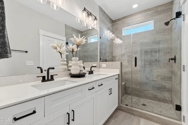 a bathroom with a sink a mirror and a shower