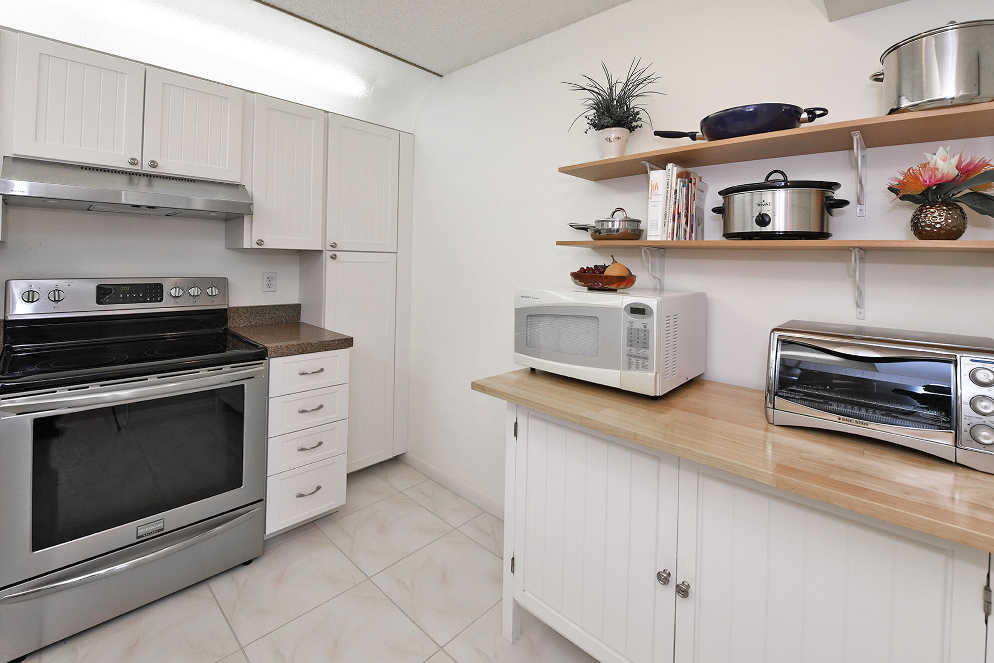 8541 Boca Glades Boulevard West, Unit A Boca Raton, FL 33434 - Photo 12 of 41 a kitchen with stainless steel appliances granite countertop a stove and a cabinets
