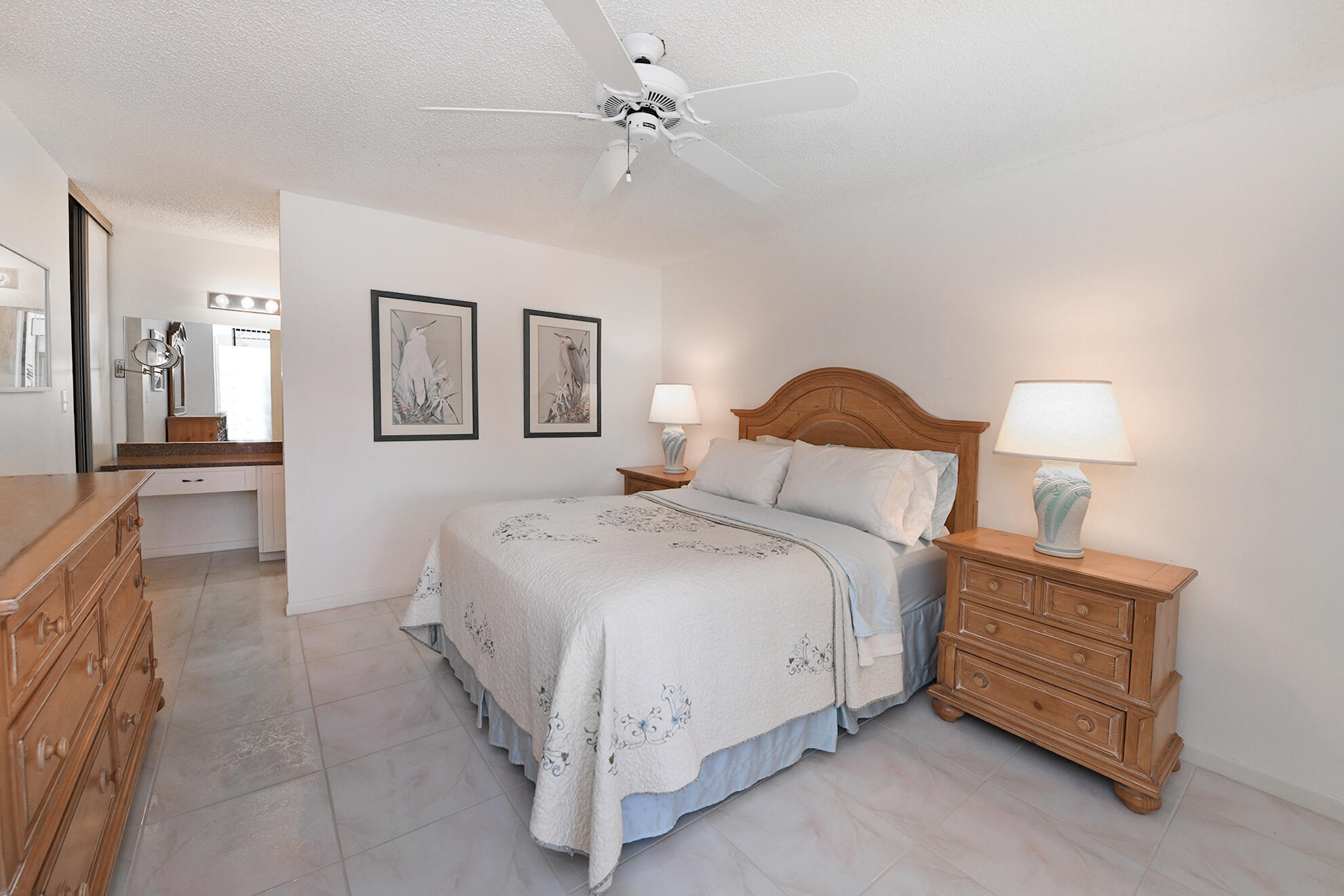 8541 Boca Glades Boulevard West, Unit A Boca Raton, FL 33434 - Photo 16 of 41 a spacious bedroom with a bed a dresser and a chandelier