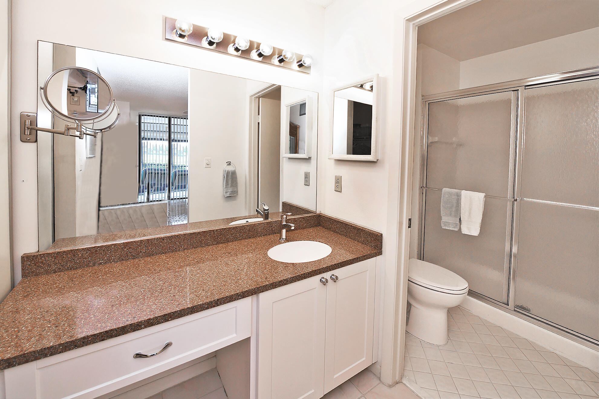 8541 Boca Glades Boulevard West, Unit A Boca Raton, FL 33434 - Photo 18 of 41 a bathroom with a sink a toilet and a mirror