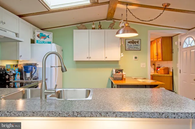 a kitchen with stainless steel appliances granite countertop a sink a stove and a refrigerator