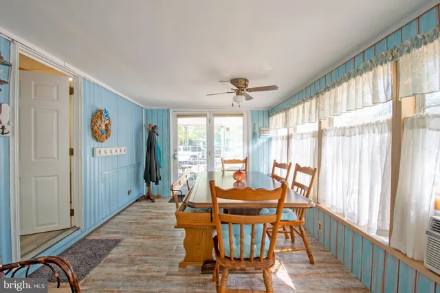 a dining room with furniture a chandelier and wooden floor