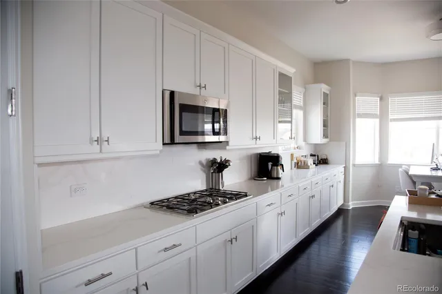 a kitchen with appliances a sink and cabinets