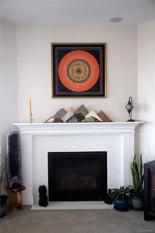 a living room with a fireplace and a potted plant