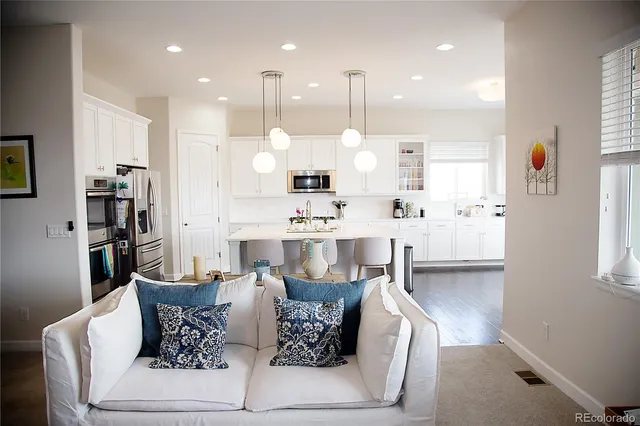 a living room with furniture kitchen view and a window