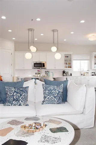 a large kitchen with a large counter top space a sink stainless steel appliances and cabinets