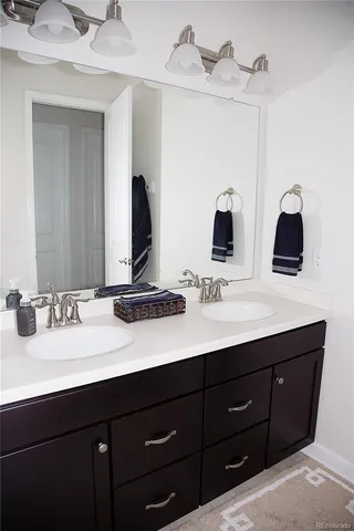 a bathroom with a double vanity sink and a mirror