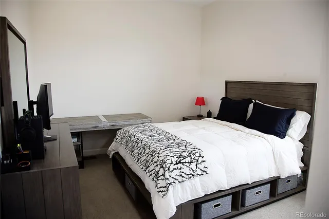 a bedroom with a bed and teddy bear on bed