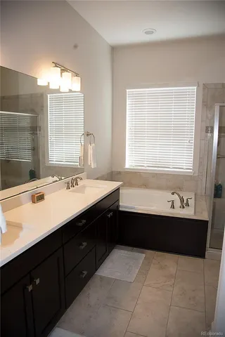 a bathroom with a bathtub sink shower and mirror