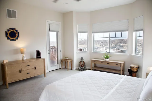 a bedroom with a bed and a large window