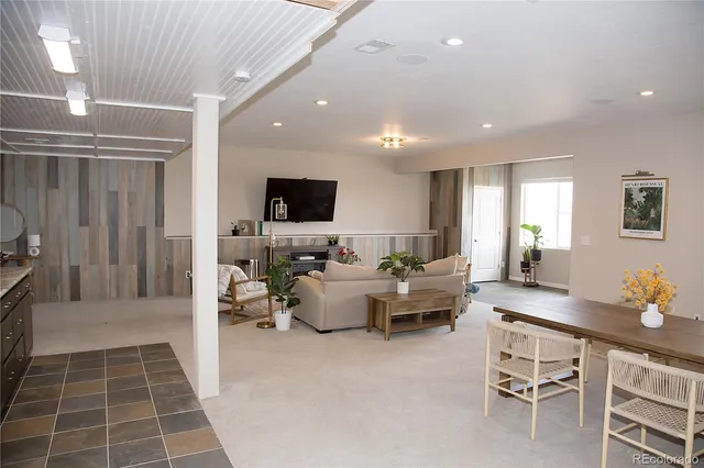 a living room with furniture a flat screen tv and a window