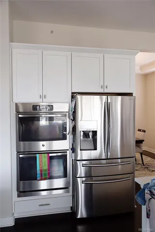 a metallic refrigerator and stove sitting inside of a kitchen