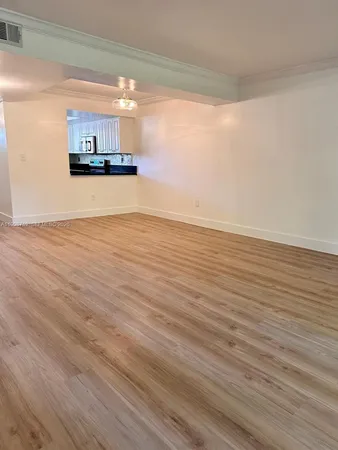 a view of a room with wooden floor and window