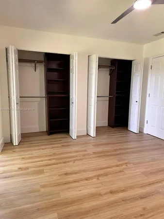 a view of an empty room with closet and cabinet