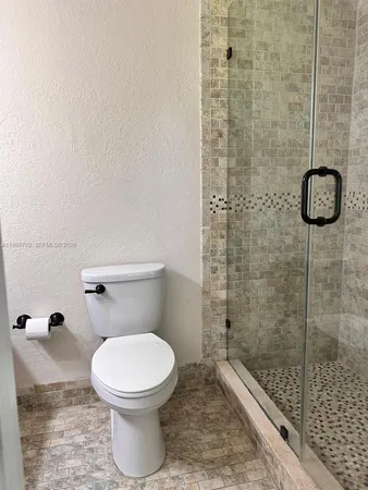 a bathroom with a toilet and a shower