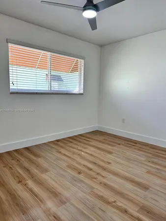 en empty room with wooden floor and windows