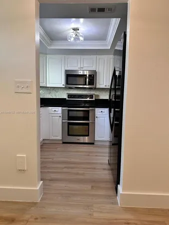a view of kitchen with sink and refrigerator