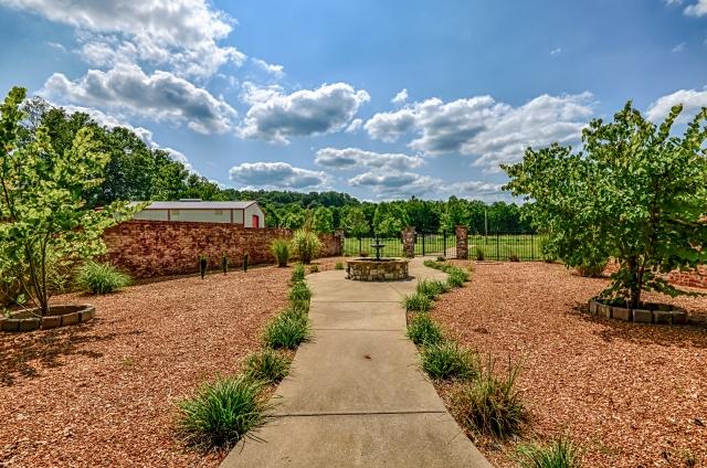 600 Bruce Road Dickson, TN 37055 - Photo 16 of 20 Behind the home, you'll find this charming courtyard, with a pathway through the pebble stone garden and peaceful fountain, bordered by a brick surround with stone columns and aluminum fence with gate; one of the home's many amazing outdoor spaces.