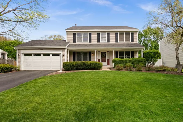 a front view of a house with a yard and trees