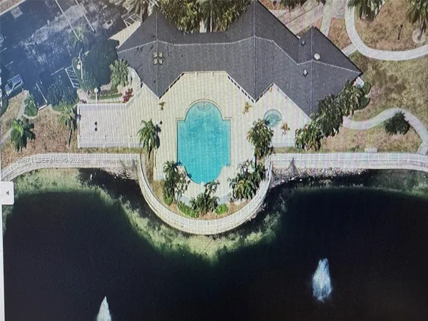 an aerial view of a house with garden space and a lake view