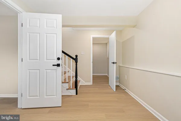 an empty room with wooden floor and mirror