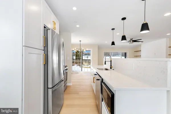a view of an empty room with a window and kitchen view