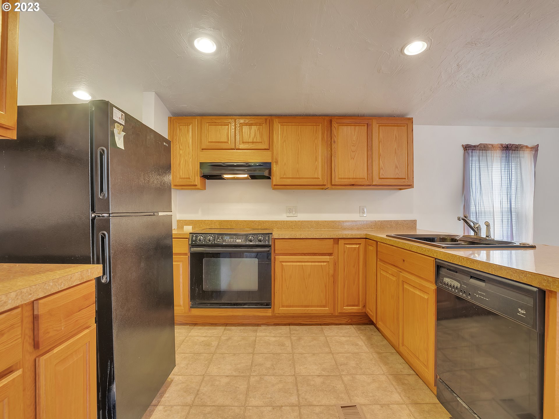 38486 Strawbridge Parkway Sandy, OR 97055 - Photo 11 of 19 a kitchen with stainless steel appliances granite countertop a refrigerator a sink a stove with wooden cabinets