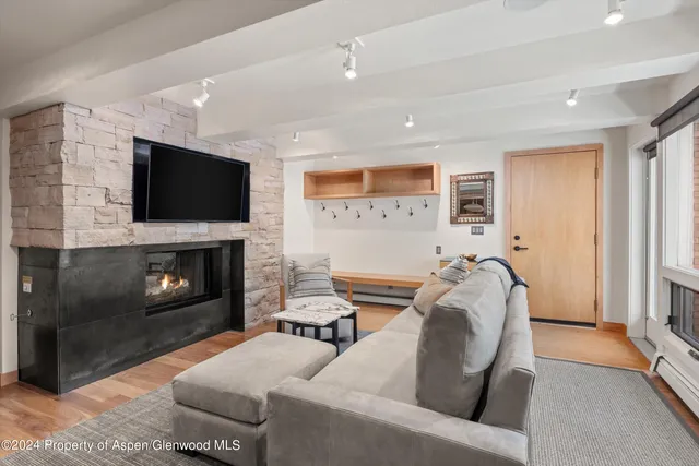 a living room with furniture a fireplace and a flat screen tv