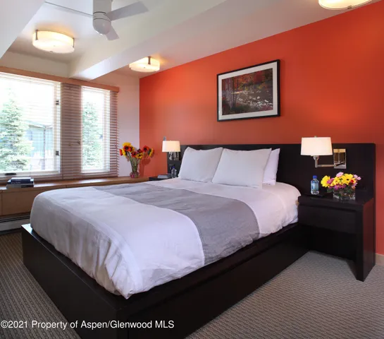 a bedroom with a bed and a large window