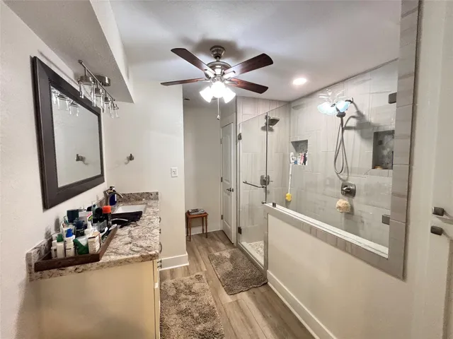 a bathroom with a tub sink mirror and shower