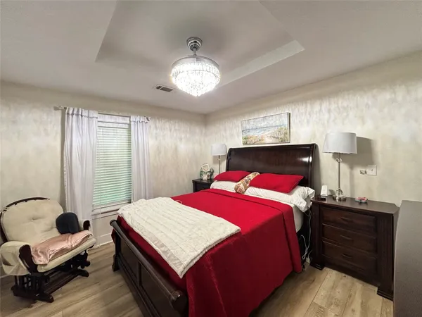 a bedroom with a bed and a chandelier