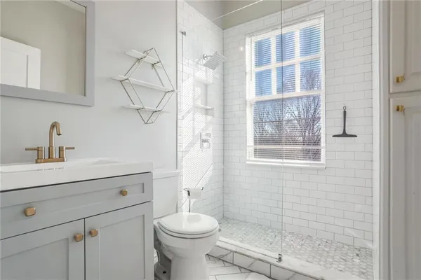 a bathroom with a sink a toilet and shower