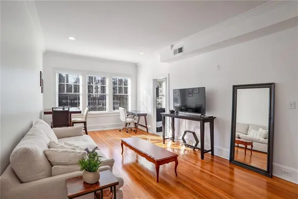 a living room with furniture a flat screen tv and a large window
