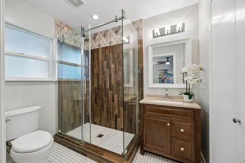 a bathroom with a sink a toilet and shower