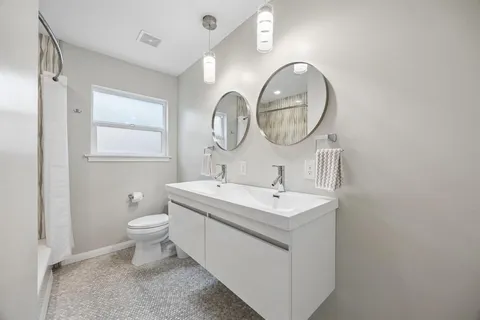 a bathroom with a toilet sink and mirror