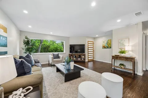 a living room with furniture a fireplace and a flat screen tv
