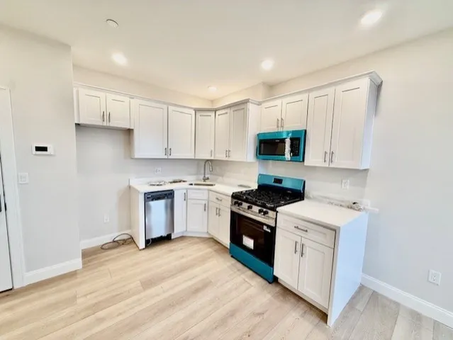 a kitchen with a stove a sink and a microwave